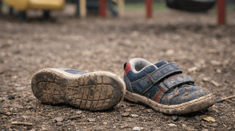 Abandoned, muddy shoes on playground