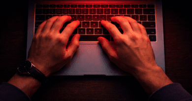 Hands typing on a laptop keyboard.