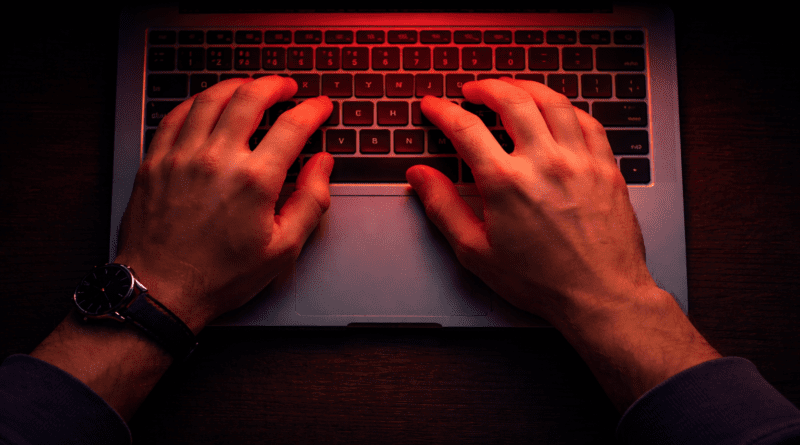 Hands typing on a laptop keyboard.